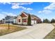 Home exterior showing long driveway to a two car garage and manicured lawn at 3924 Bear Creek Way, Carmel, IN 46074