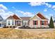 Charming single-story home with stone and red siding, complemented by a well-manicured lawn and blue sky at 3924 Bear Creek Way, Carmel, IN 46074