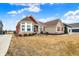 Beautiful single-story home featuring stone and red siding, complemented by lush green landscaping at 3924 Bear Creek Way, Carmel, IN 46074