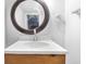 Bathroom featuring a wood vanity, a round mirror, and white walls at 4249 Dubarry Rd, Indianapolis, IN 46226