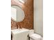 Powder room featuring a vessel sink and round mirror on mosaic tile accent wall at 501 Fletcher Ave # D, Indianapolis, IN 46203