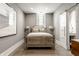 Neutral bedroom showcases a bed, stained glass window and sliding door to ensuite bathroom at 501 Fletcher Ave # D, Indianapolis, IN 46203