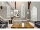 Open living room with soaring ceilings, original stained glass windows, and neutral color palette at 501 Fletcher Ave # D, Indianapolis, IN 46203