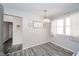Bright dining area featuring gray wood-look floors, a chandelier, and a large window at 540 Barnett Ct, Whiteland, IN 46184