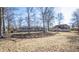 Expansive backyard with a view of the home's stone exterior and surrounding trees at 5502 Radnor Rd, Indianapolis, IN 46226