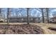 Back of house with stone facade and patio in a leafy backyard, surrounded by mature trees at 5502 Radnor Rd, Indianapolis, IN 46226