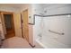 Bathroom featuring a white tub, tiled wall, and towel rack with an open doorway to the hall at 5502 Radnor Rd, Indianapolis, IN 46226