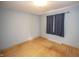 Bedroom features light hardwood floors, gray walls, window with dark curtains, and a flush ceiling light at 5502 Radnor Rd, Indianapolis, IN 46226