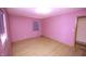 Bright bedroom featuring light hardwood floors, pink walls, window with blinds, and a flush ceiling light at 5502 Radnor Rd, Indianapolis, IN 46226