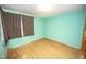Bedroom features teal walls, light hardwood floors, and window with dark blinds at 5502 Radnor Rd, Indianapolis, IN 46226