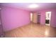 Bedroom features pink walls, light hardwood floors, adjacent closet, and bathroom with a black vanity at 5502 Radnor Rd, Indianapolis, IN 46226