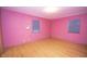 Spacious bedroom boasting hardwood floors, two windows with blinds, and freshly painted pink walls at 5502 Radnor Rd, Indianapolis, IN 46226
