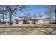 Single-story stone home with attached garage, framed by mature trees and a neatly kept lawn at 5502 Radnor Rd, Indianapolis, IN 46226
