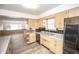 A kitchen features wood cabinets, a stainless steel dishwasher, and a view into the living room at 5502 Radnor Rd, Indianapolis, IN 46226