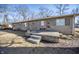 Rear of home with stone facade, patio, and steps leading to a well-maintained backyard at 5502 Radnor Rd, Indianapolis, IN 46226