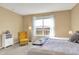 Bright bedroom filled with natural light from large windows and cozy yellow chair at 5751 Bluff View Ln, Whitestown, IN 46075