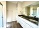 Bathroom featuring a double sink vanity with granite countertop, large mirror, and white cabinets at 614 Silver Fox Ct, Indianapolis, IN 46217