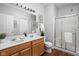 Bathroom with a double sink vanity, updated lighting, and a glass-enclosed shower at 6537 Amherst Way, Zionsville, IN 46077