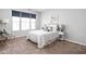 Bright bedroom with a comfortable bed, soft lighting, and a large window with custom window treatments at 6537 Amherst Way, Zionsville, IN 46077
