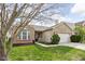 Beautifully landscaped front yard of a brick home featuring green grass, mulch beds, and a welcoming porch at 6537 Amherst Way, Zionsville, IN 46077