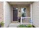 Close-up of a charming front porch with potted plants, a welcome mat, and an ADT security sign at 6537 Amherst Way, Zionsville, IN 46077
