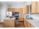 Bright kitchen with stainless steel appliances, wooden cabinetry, and center island at 6537 Amherst Way, Zionsville, IN 46077