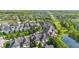 Bird's-eye view of homes nestled amidst trees and green spaces, with a pond adding a scenic touch to the neighborhood at 6691 Beekman Pl, Zionsville, IN 46077