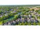 Aerial view of a scenic neighborhood, showcasing a tranquil pond, green trees, and attractive homes in a peaceful setting at 6691 Beekman Pl, Zionsville, IN 46077
