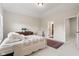 Cozy bedroom with a tray ceiling, plush bed, and a view into the ensuite bathroom at 6691 Beekman Pl, Zionsville, IN 46077
