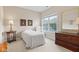 Bright bedroom features a cozy chair, a dresser, and natural light from the window at 6691 Beekman Pl, Zionsville, IN 46077
