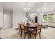 Elegant dining room with a wood table, upholstered chairs, and abundant natural light from large windows at 6691 Beekman Pl, Zionsville, IN 46077