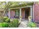 Inviting front porch with a table, chairs, planters and a brick exterior at 6691 Beekman Pl, Zionsville, IN 46077
