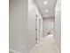 Well-lit hallway leads to a bedroom with a cozy chair and a view of the outdoors at 6691 Beekman Pl, Zionsville, IN 46077