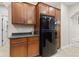 Cozy kitchen area features ample wooden cabinetry and a black refrigerator at 6691 Beekman Pl, Zionsville, IN 46077