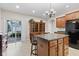 Spacious kitchen features a central island, dark appliances, and sliding glass doors leading to the outdoors at 6691 Beekman Pl, Zionsville, IN 46077