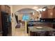 Well-equipped kitchen with dark cabinets, granite countertops, and a view into the elegant living space at 6691 Beekman Pl, Zionsville, IN 46077