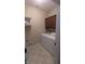 Functional laundry room with washer, dryer, shelving, and practical tile flooring at 6691 Beekman Pl, Zionsville, IN 46077