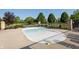 Small, in-ground pool surrounded by a concrete deck, black metal fence, and lounge chairs at 6691 Beekman Pl, Zionsville, IN 46077