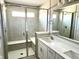 Modern bathroom with glass shower, a built-in bench, and double sink vanity with white cabinets at 6882 Equality Blvd, Carmel, IN 46033