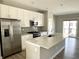 Modern kitchen with stainless steel appliances, a large island, and white cabinets with grey backsplash at 6882 Equality Blvd, Carmel, IN 46033