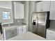 A modern kitchen featuring stainless steel appliances, light grey backsplash, and ample white cabinetry at 6882 Equality Blvd, Carmel, IN 46033