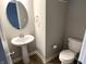 Modern half-bathroom with a pedestal sink and sleek fixtures for guests' convenience at 6882 Equality Blvd, Carmel, IN 46033