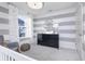 Stylish bedroom showcasing gray and white striped walls, a black dresser with a round mirror, and elegant curtains at 7156 Firestone Rd, Whitestown, IN 46052