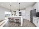 Bright kitchen featuring a kitchen island, modern lighting, stainless steel appliances, and wood-look flooring at 7156 Firestone Rd, Whitestown, IN 46052