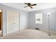 Bright bedroom features a ceiling fan, a window, and a closet at 725 Queenswood Dr, Indianapolis, IN 46217