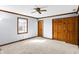 Bright bedroom features a ceiling fan, neutral carpet, a window, and a closet at 725 Queenswood Dr, Indianapolis, IN 46217