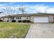 Stone-clad ranch home with attached garage and a concrete driveway at 725 Queenswood Dr, Indianapolis, IN 46217