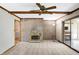 Comfortable living room boasts a beautiful brick fireplace, ceiling fan, and access to other rooms at 725 Queenswood Dr, Indianapolis, IN 46217