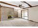 Spacious living room features a ceiling fan, a brick fireplace, and sliding doors to sunroom at 725 Queenswood Dr, Indianapolis, IN 46217