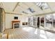 Bright sunroom features skylights, tile floor, a fireplace, and sliding glass doors to a backyard at 725 Queenswood Dr, Indianapolis, IN 46217